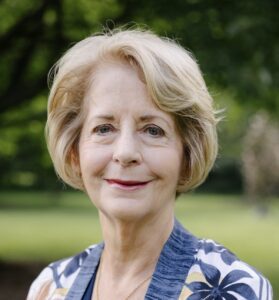 A woman with blonde hair and blue shirt.